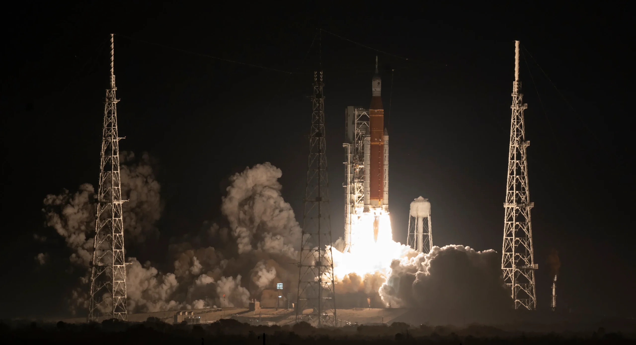 A rocket lifting off at night from the launch pad